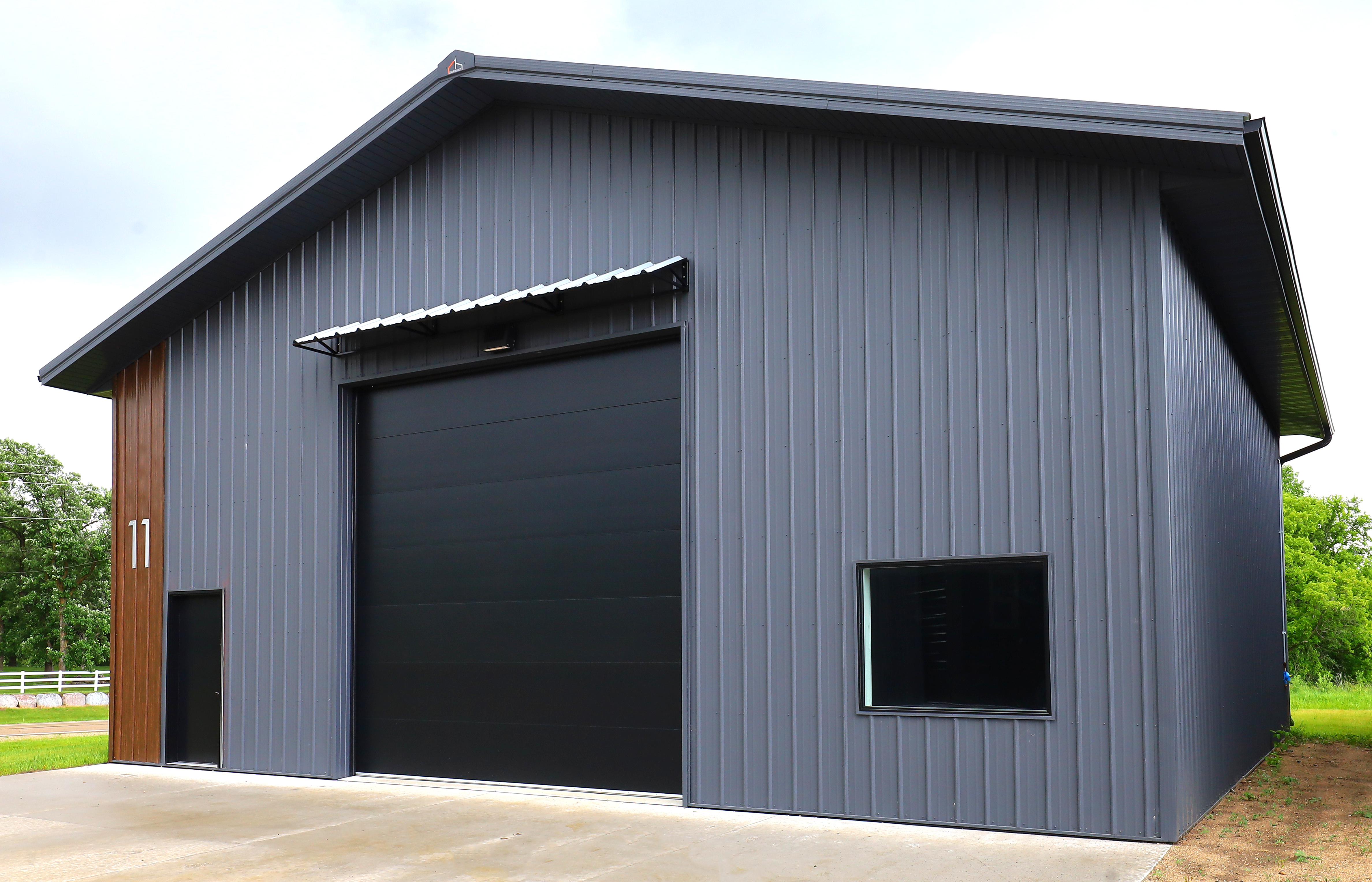 Lakes Area Storage Complex building with gray metal siding and black overhead door
